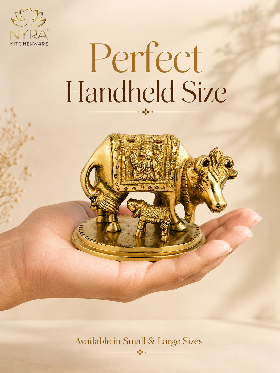 A hand holding a small brass cow and calf statue, with promotional text reading 'Perfect Handheld Size' and the brand logo 'NTRA Kitchenware' on a warm beige background.