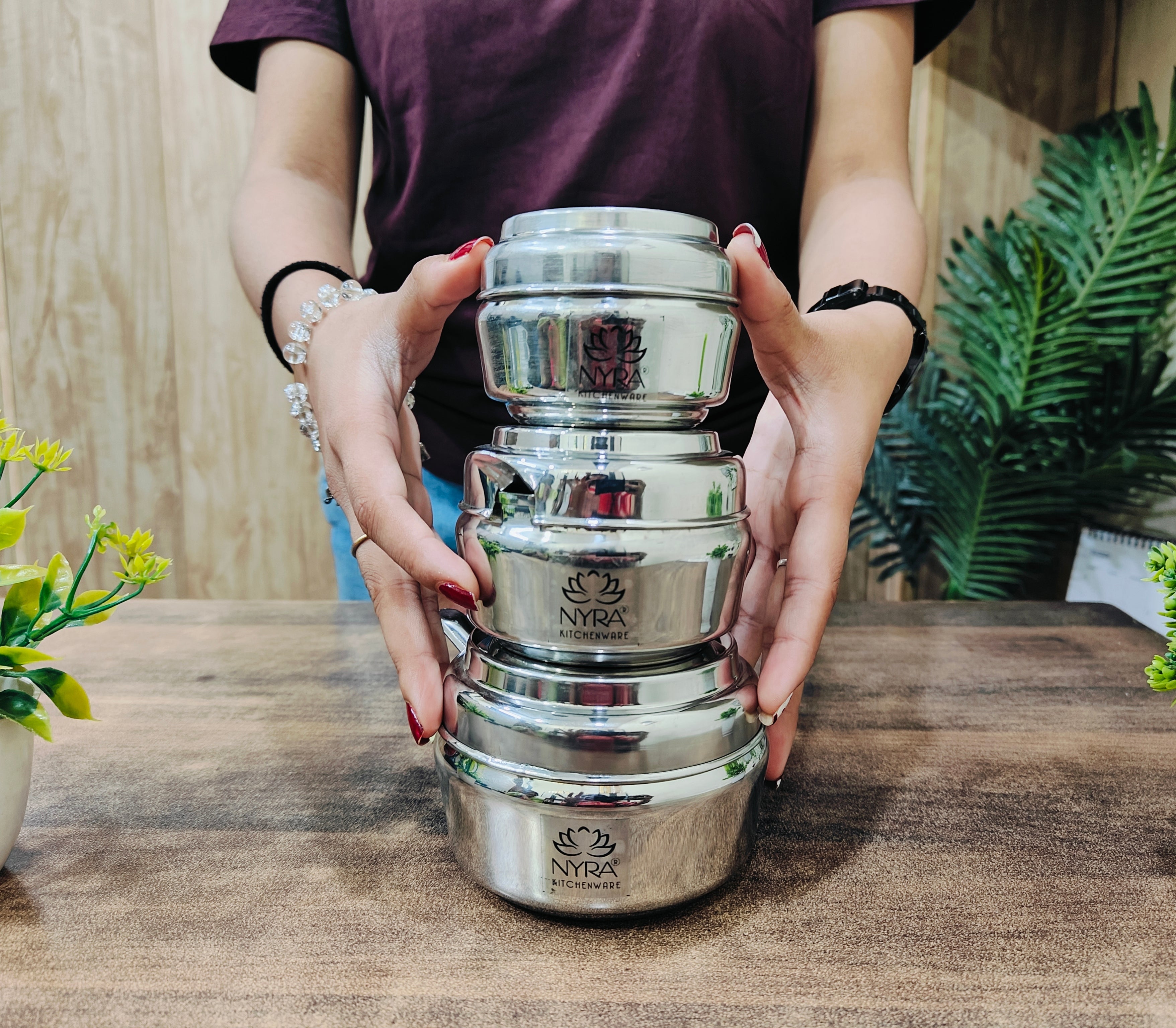 showing in hand all the sizes of Stainless Steel Ghee Pot & Oil Container 