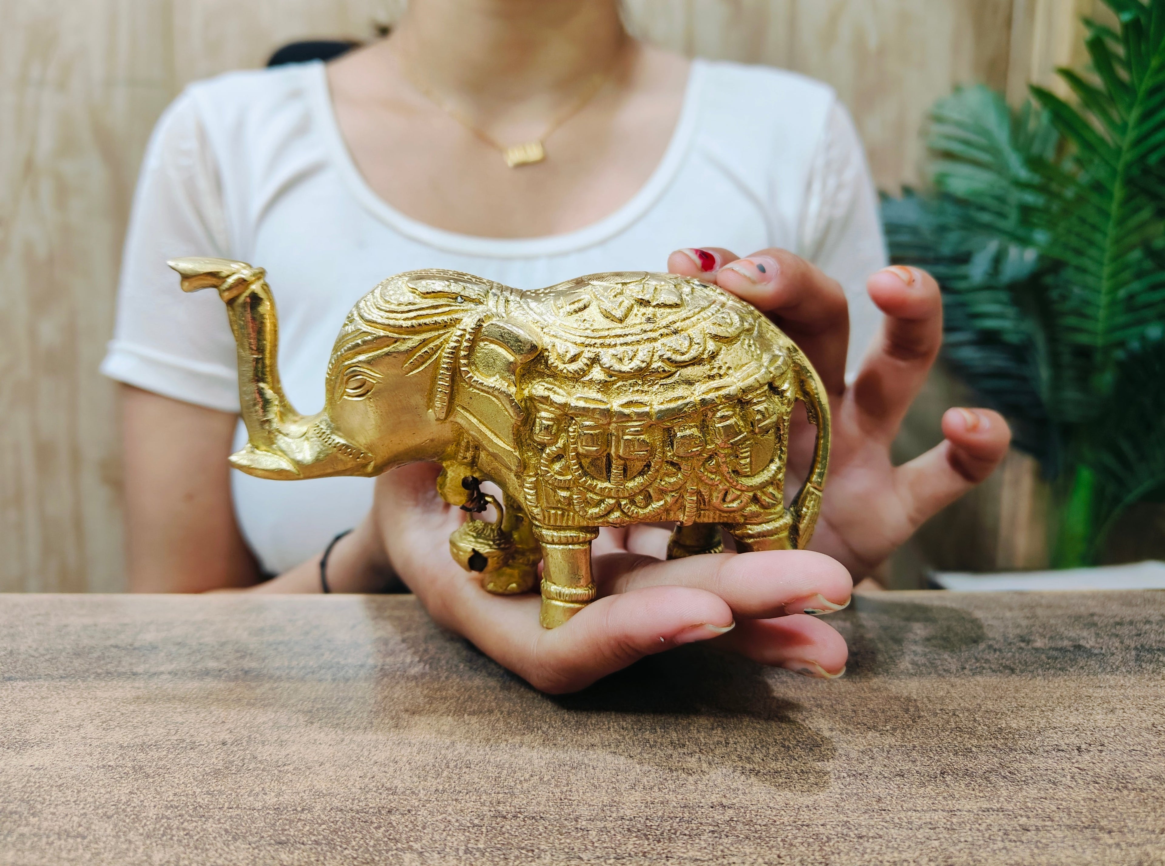showing in hand view of Handcrafted Pure Brass Elephant Figurine with Bell 