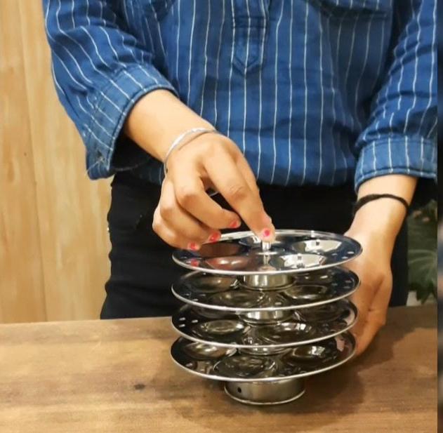 showing in hand Stainless Steel Mini Idli Maker