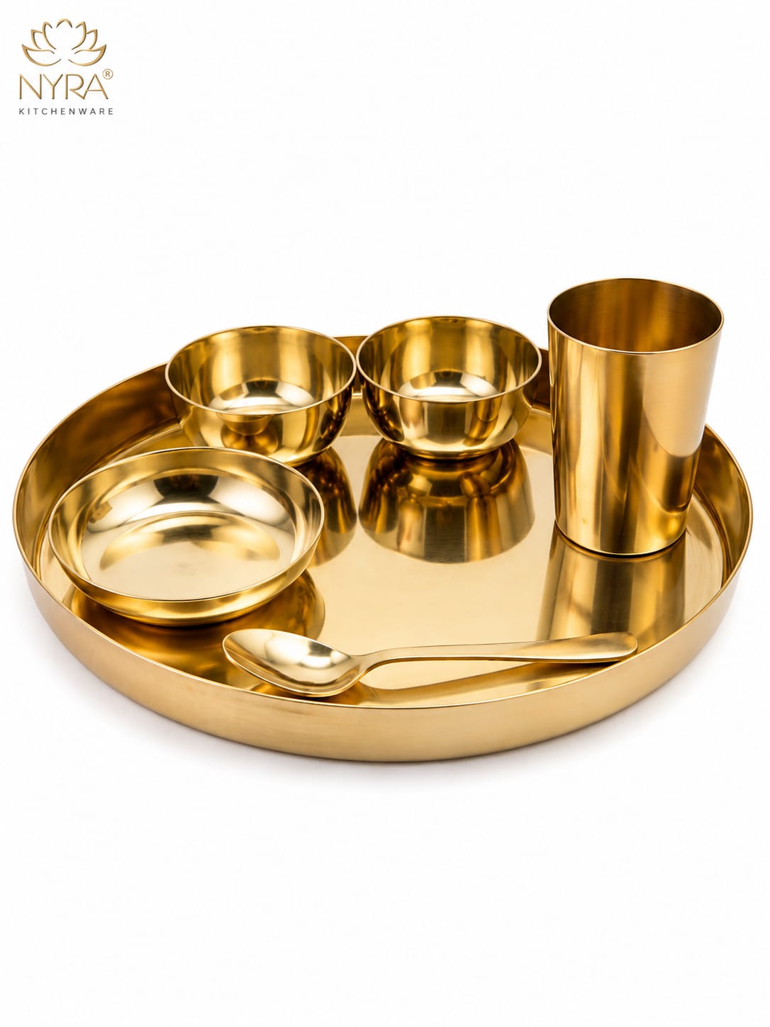A gold-plated brass Indian thali set on a white background, featuring a round tray, a small cup, two bowls, a spoon, and a plate, with the NYRA Kitchenware logo in the top left corner.
